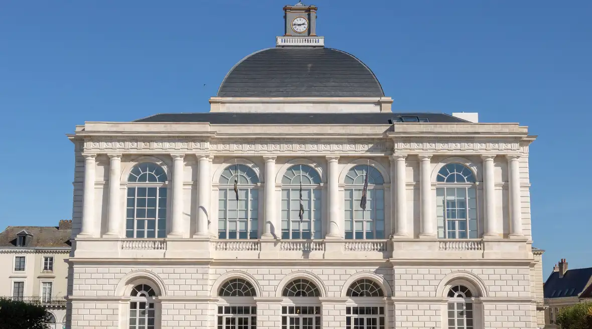 A pavilion-style white building with a clear blue sky behind it.