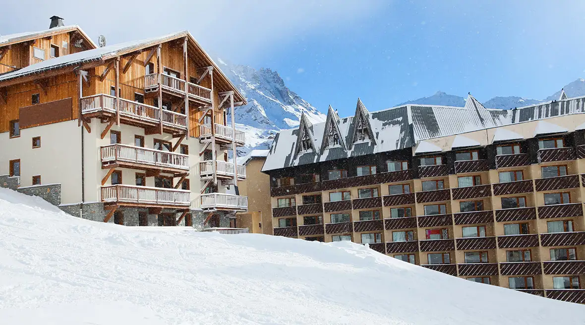 two large snow apartment blocks with balconies set into huge white snow banks
