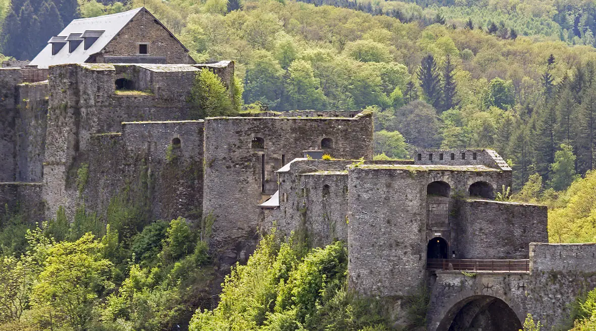 Castle ruins set into a lush, green hillside