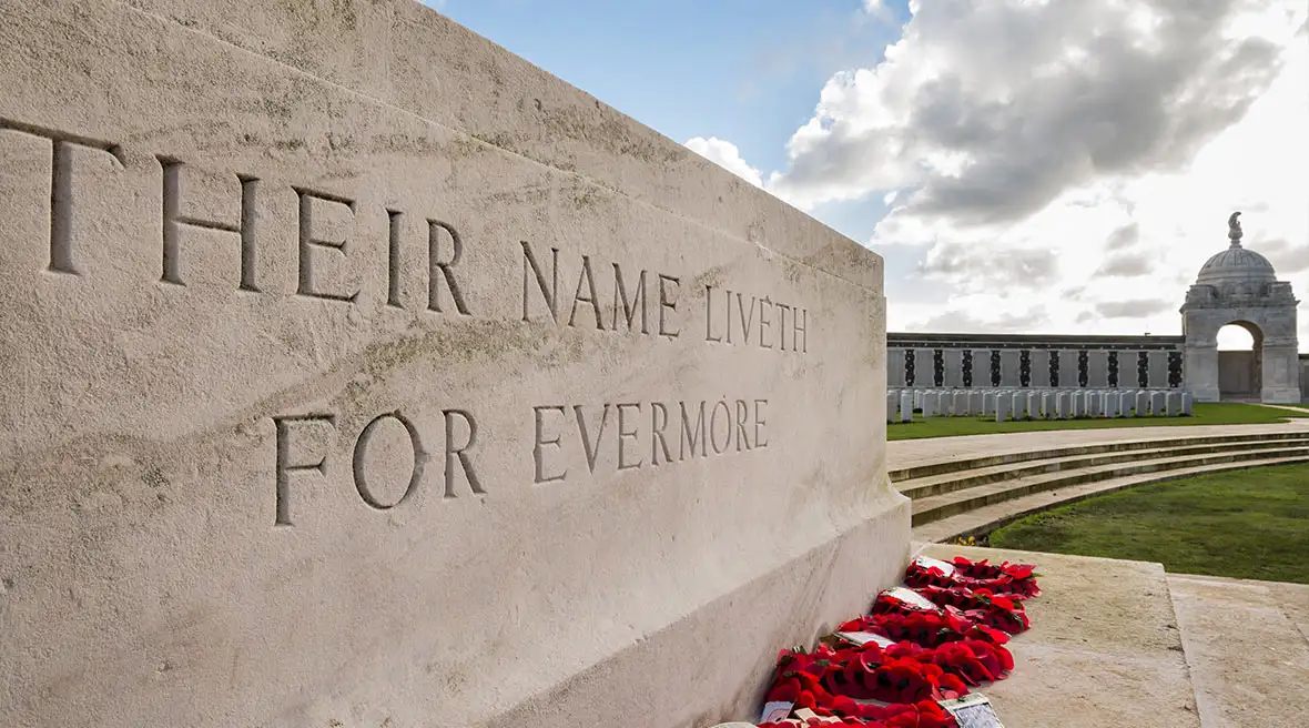 A memorial to the missing in WW1 on a stone plinth that reads their names liveth for evermore with poppy wreaths below
