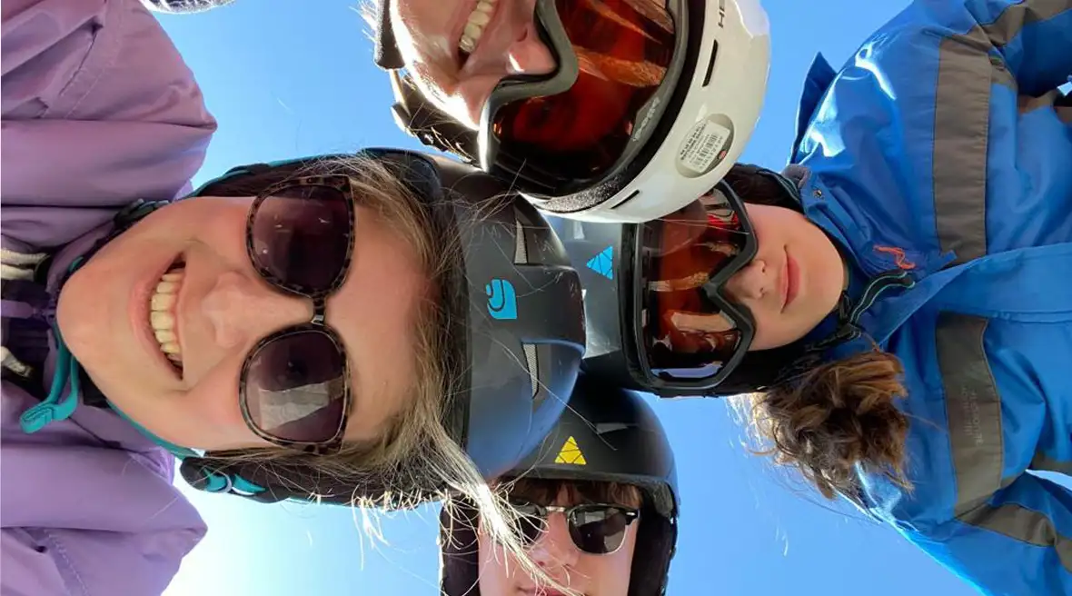 Family pose in ski gear excited for the first day on the slopes on their beginners’ ski holiday in Val Cenis.