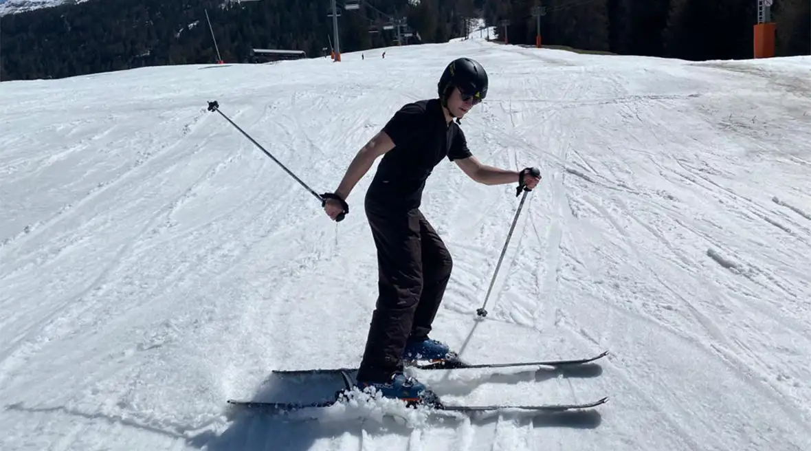 By the end of the skiing holiday for beginners in Val Cenis, this teenager is proud of his new ski skills, sliding into a graceful stop.