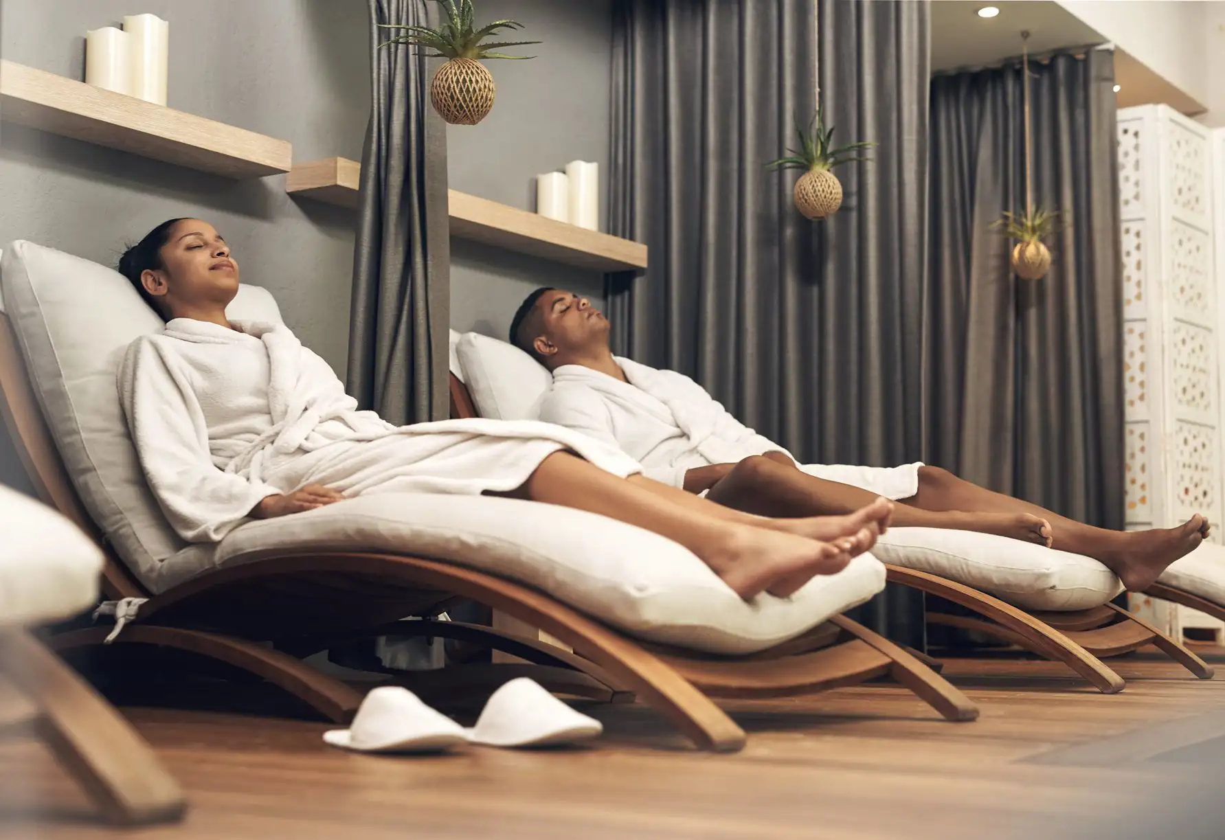 Man and woman relaxing in reclining chairs in a spa treatment room