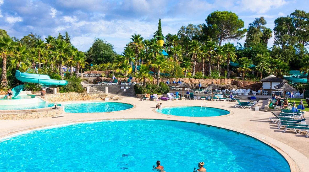 Couple swimming in round swimming pool with additional pools in the background