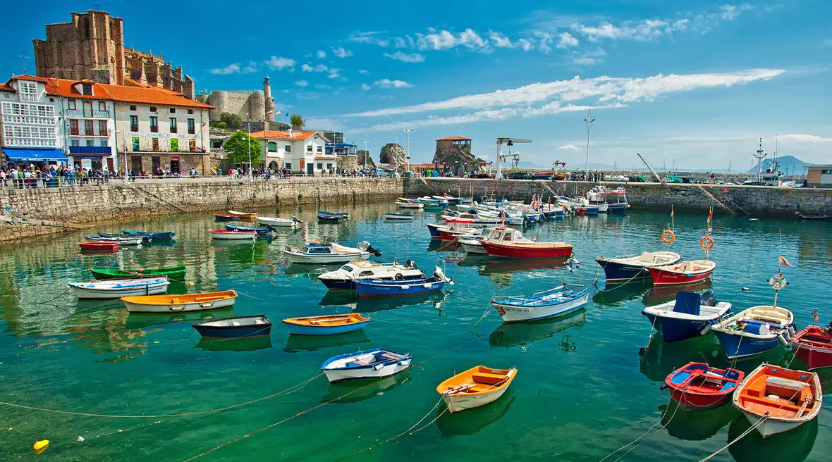 Colourful boats tied up in a harbour filled with crystal clear turquoise water