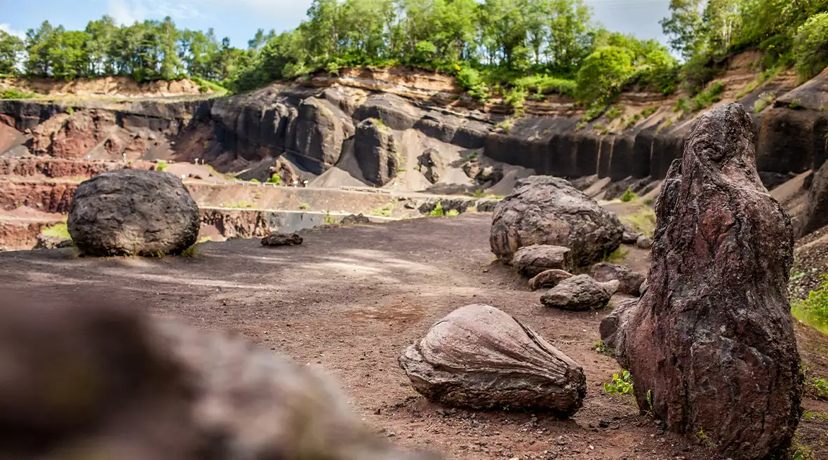 A close up of the inside of a crater vocano. The landscape is brown and large volcanic boulders dot the surface