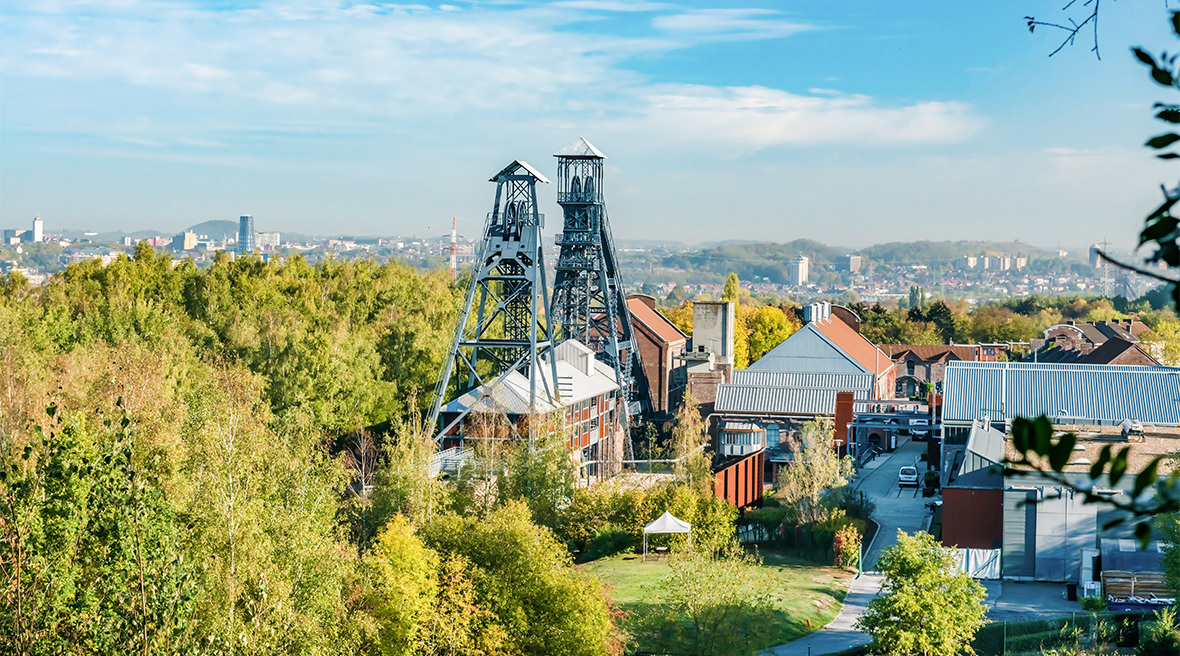 Colliery building set amid a wooded area with a city scape in the background
