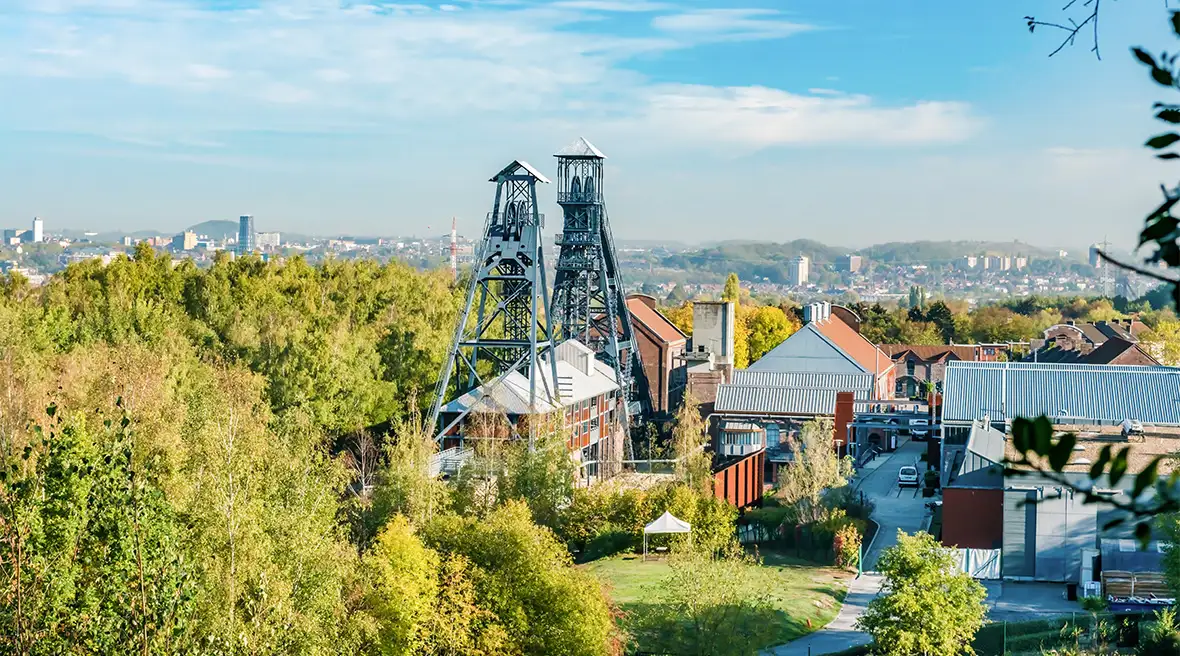 Colliery building set amid a wooded area with a city scape in the background