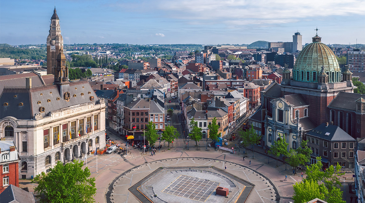 A circular city square showing a church, town hall, belfry and city streets