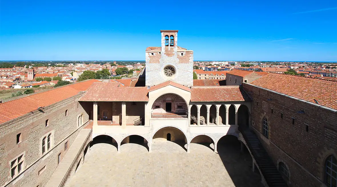 Aerial view of the Palais des rois de Majorque à Perpignan square beneath a blue sky with the city beyond