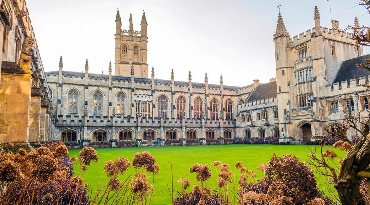 Magdalen College gezien vanuit de tuin, met uitgebloeide bloemen op de voorgrond