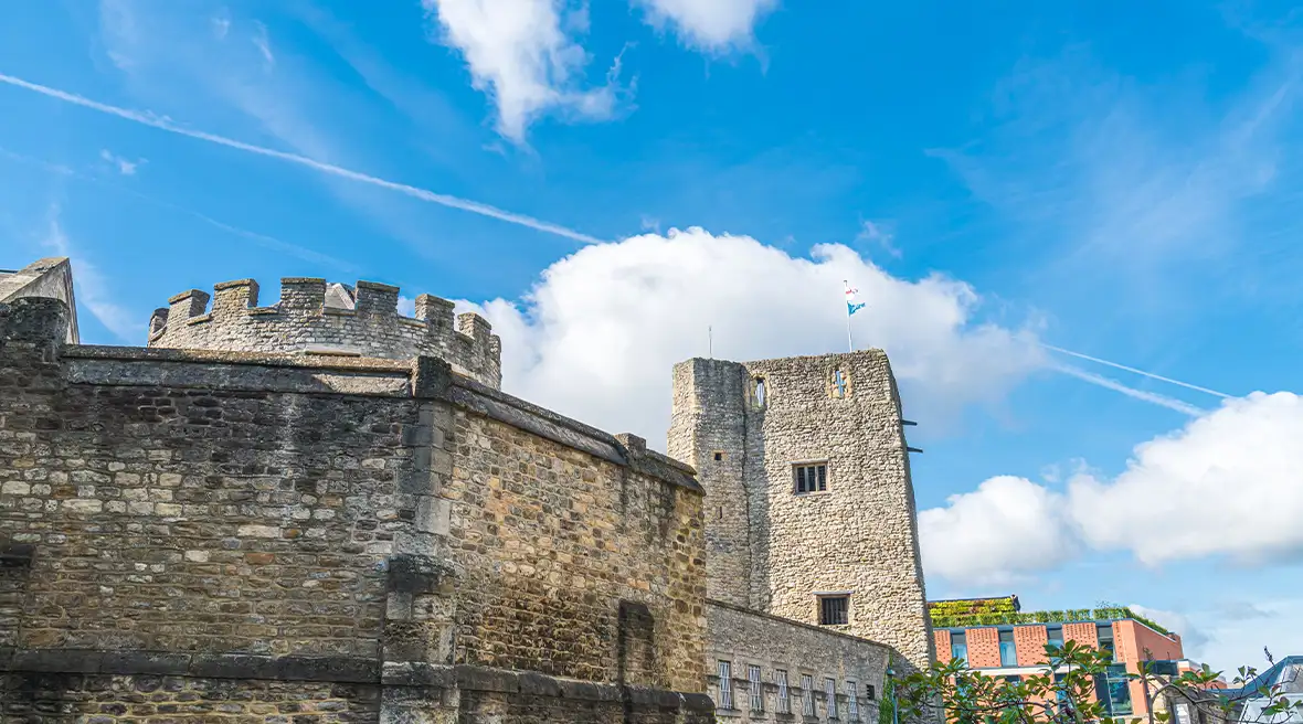 Zicht op de toren met kantelen en een ruïnemuur van Oxford Castle