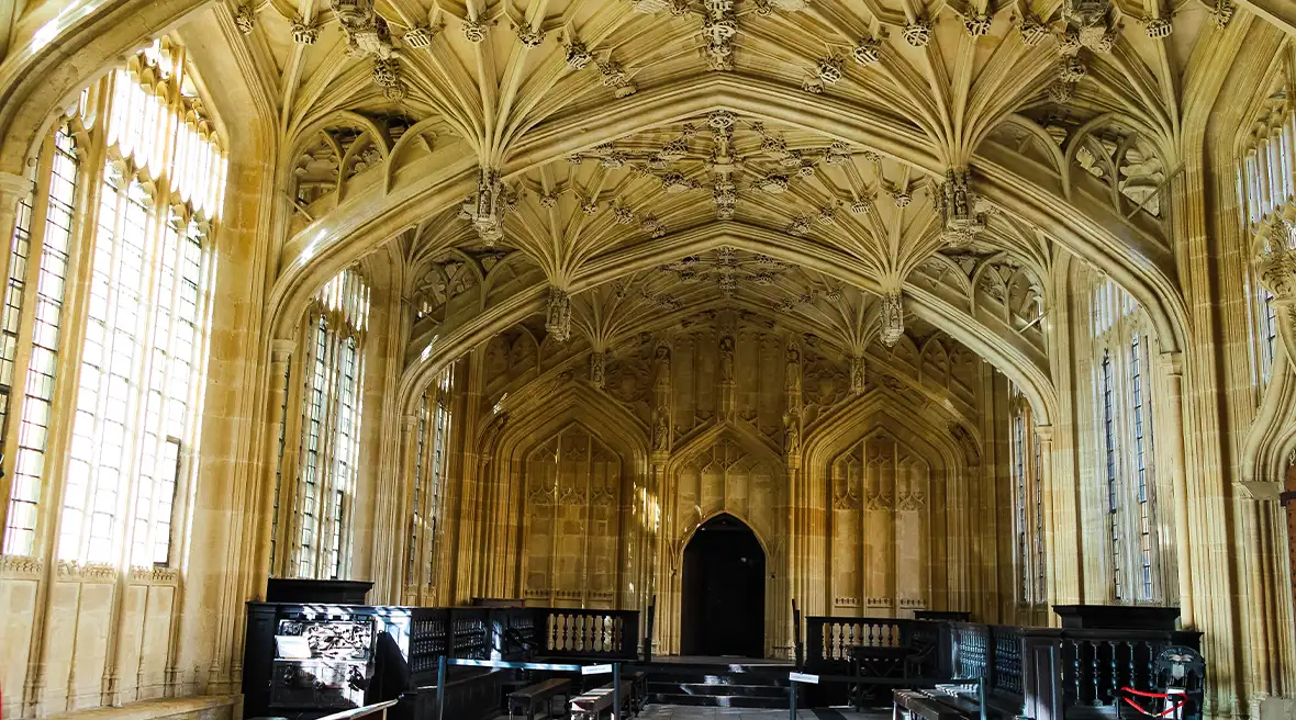 Middeleeuwse zaal met hoge ramen en gebeeldhouwde gewelven