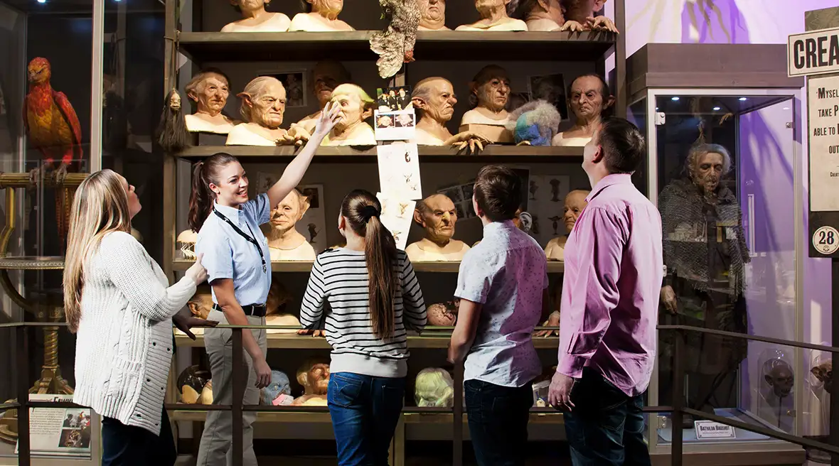 Een gids laat koboldmaskers aan bezoekers zien en legt hun rol in de productie van de film uit.