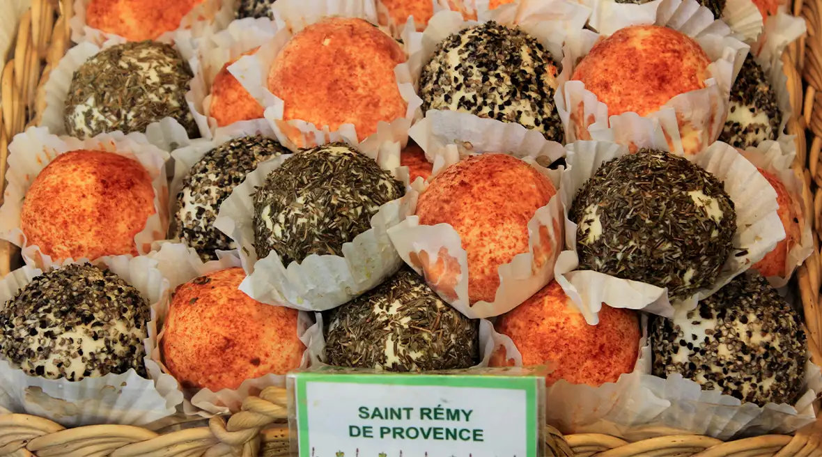 Balls of cheese in paper wrappers in a basket of a market stall or shop
