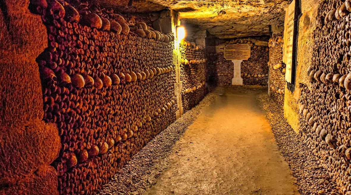 A passageway in an underground ossuary with walls lined with skulls and bones