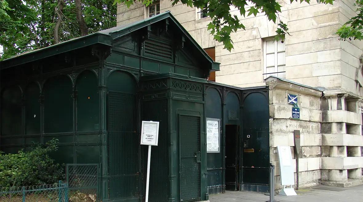 An unassuming green shed-like building on a city street