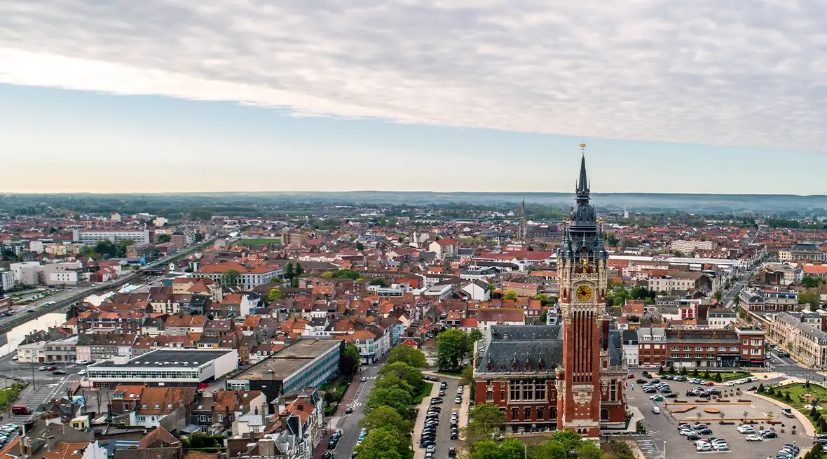 Skyline view of a French city with buildings and trees under a blue sky