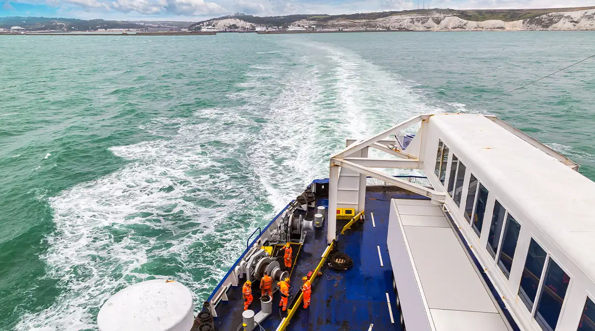 Birdseye view of a ferry moving towards land in the distance