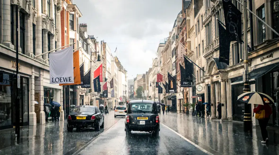 Taxi fährt an Luxusgeschäften in der Bond Street in London vorbei