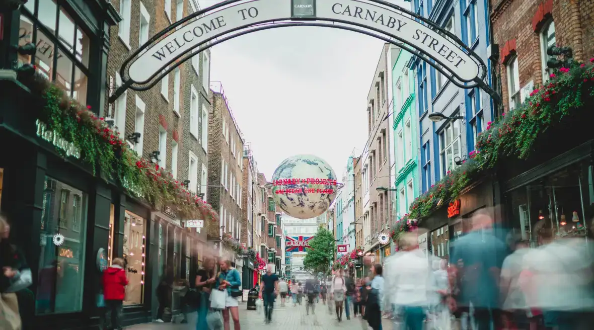 Fußgängerzone mit Boutiquen und Straßenschildern in der Carnaby Street in London