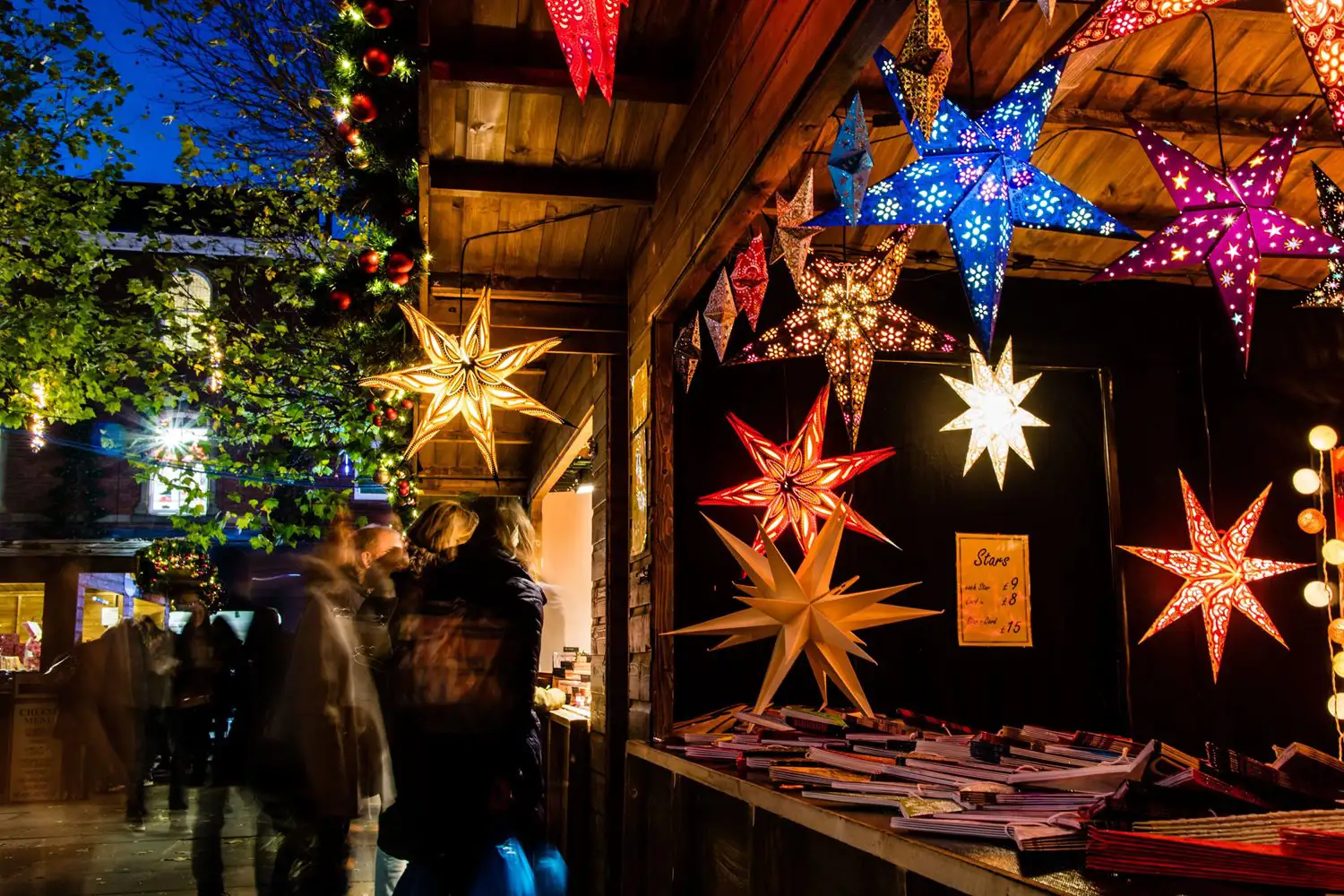 Verlichte kerststerren te koop bij een kraampje op de kerstmarkt.