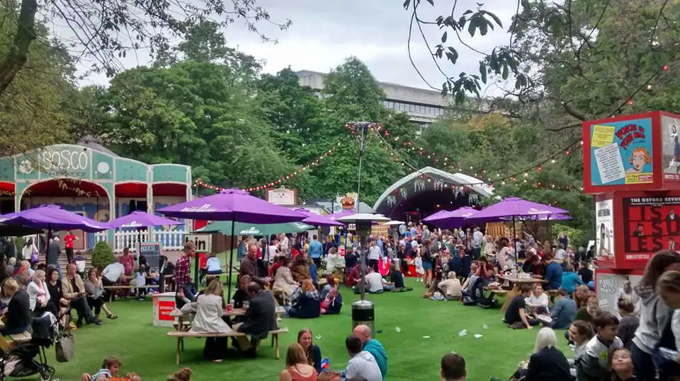 Festivalbezoekers bij een gezellige buitenbar tijdens het Edinburgh Festival.