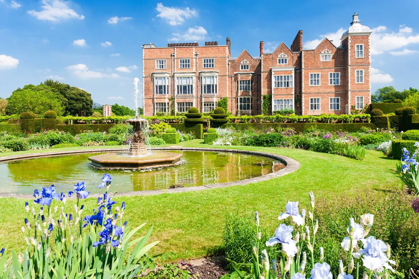 Hatfield House met de omliggende tuin, met een fontein in een vijver.
