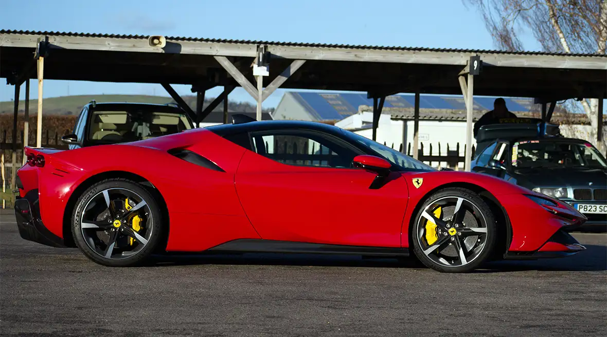 Roter Oldtimer-Ferrari mit Wellblechdach im Hintergrund