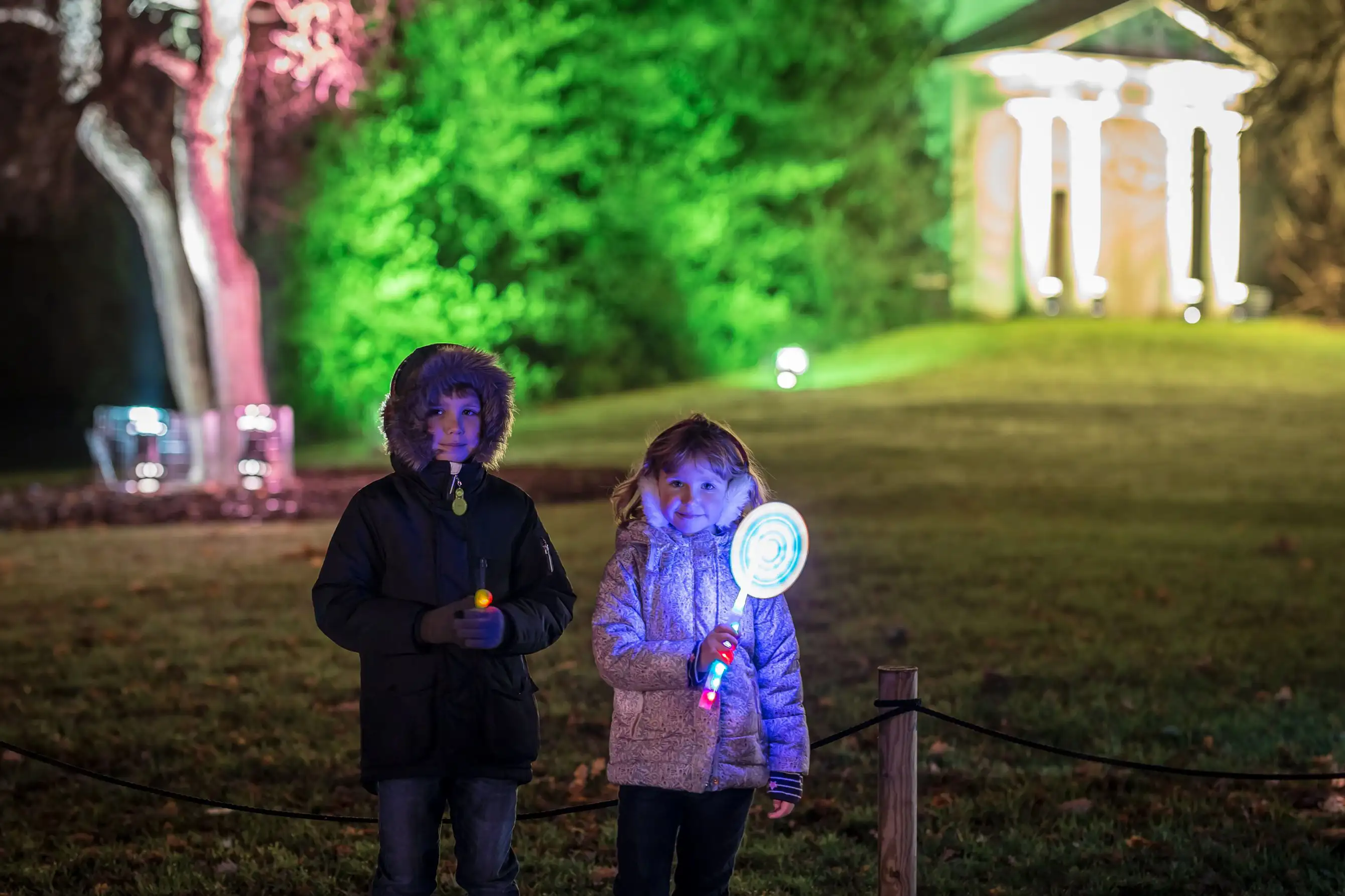 Kinder, die sich über das Lichterspektakel von Christmas at Kew freuen.