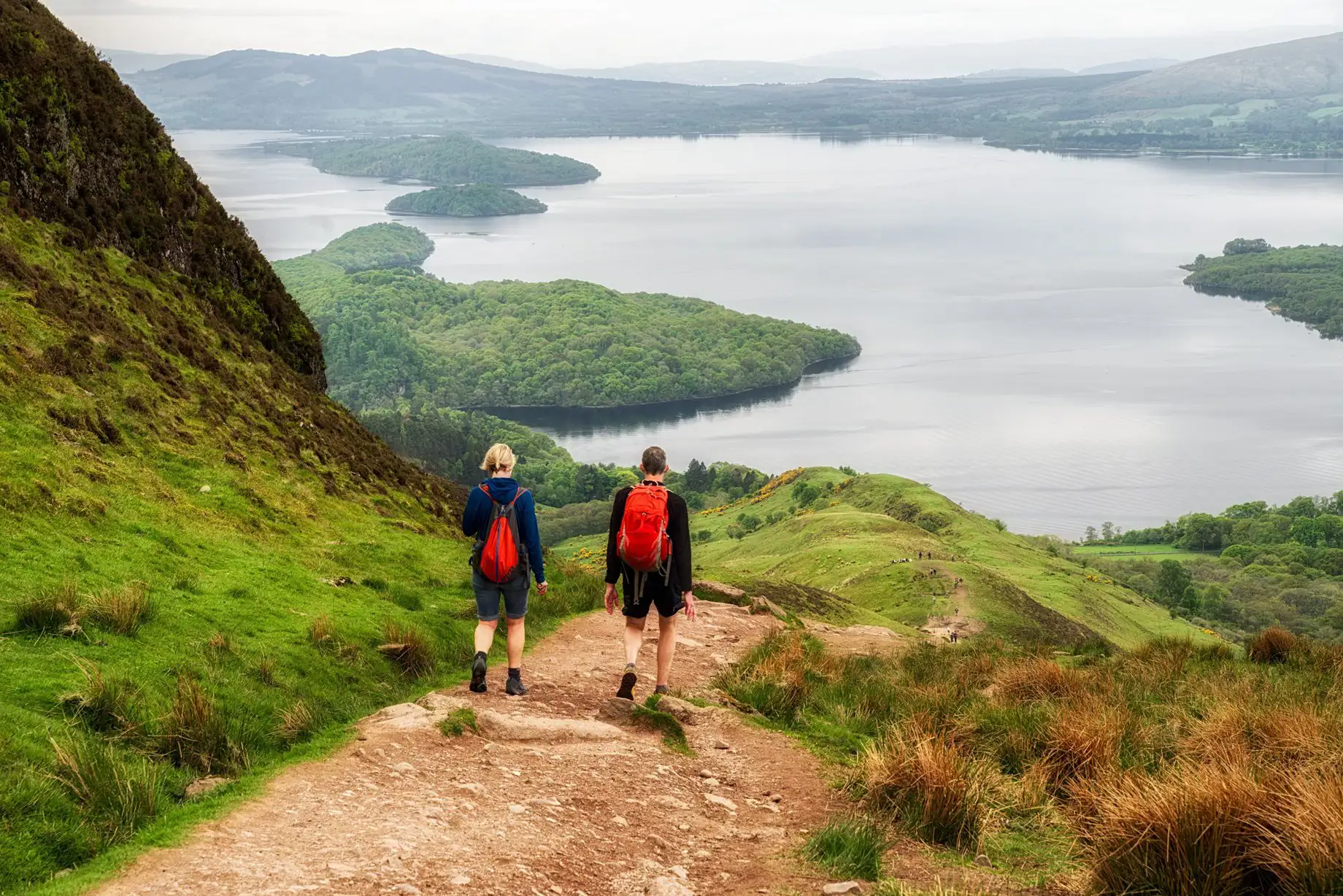 Wandelaars lopen over een pad boven Loch Lomond in Schotland.
