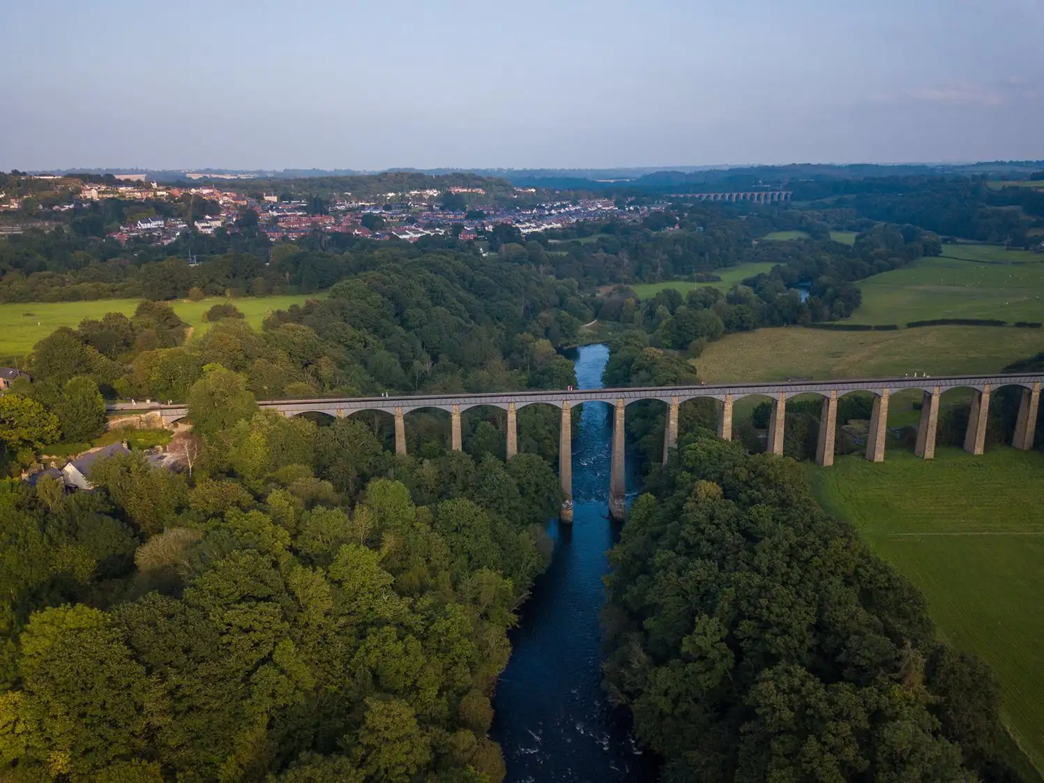 Zeer hoog aquaduct over een brede rivier.
