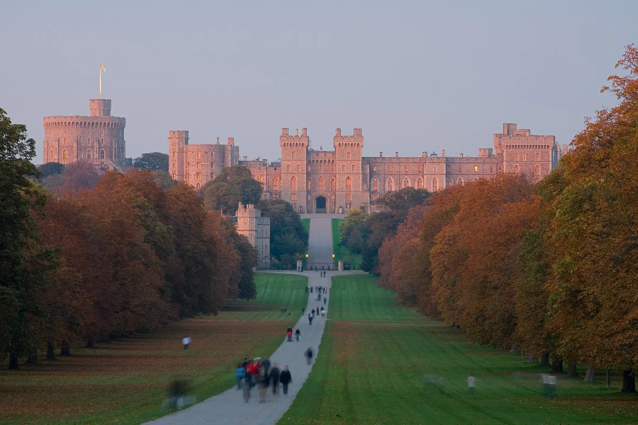 Mensen wandelen over The Long Walk naar Windsor Castle bij avondlicht