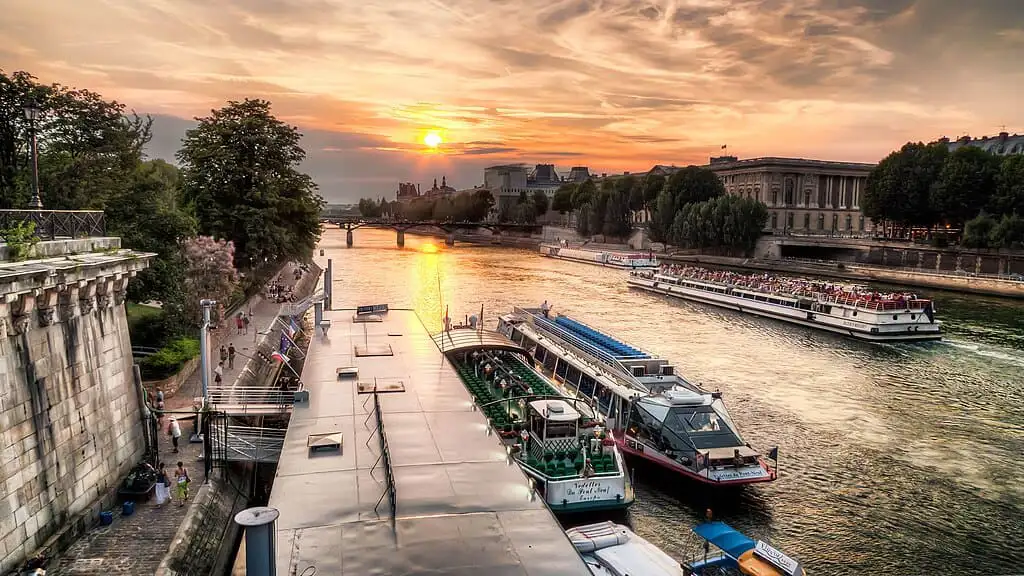 Tourist cruise boats at an embarkation point in Paris at sunset