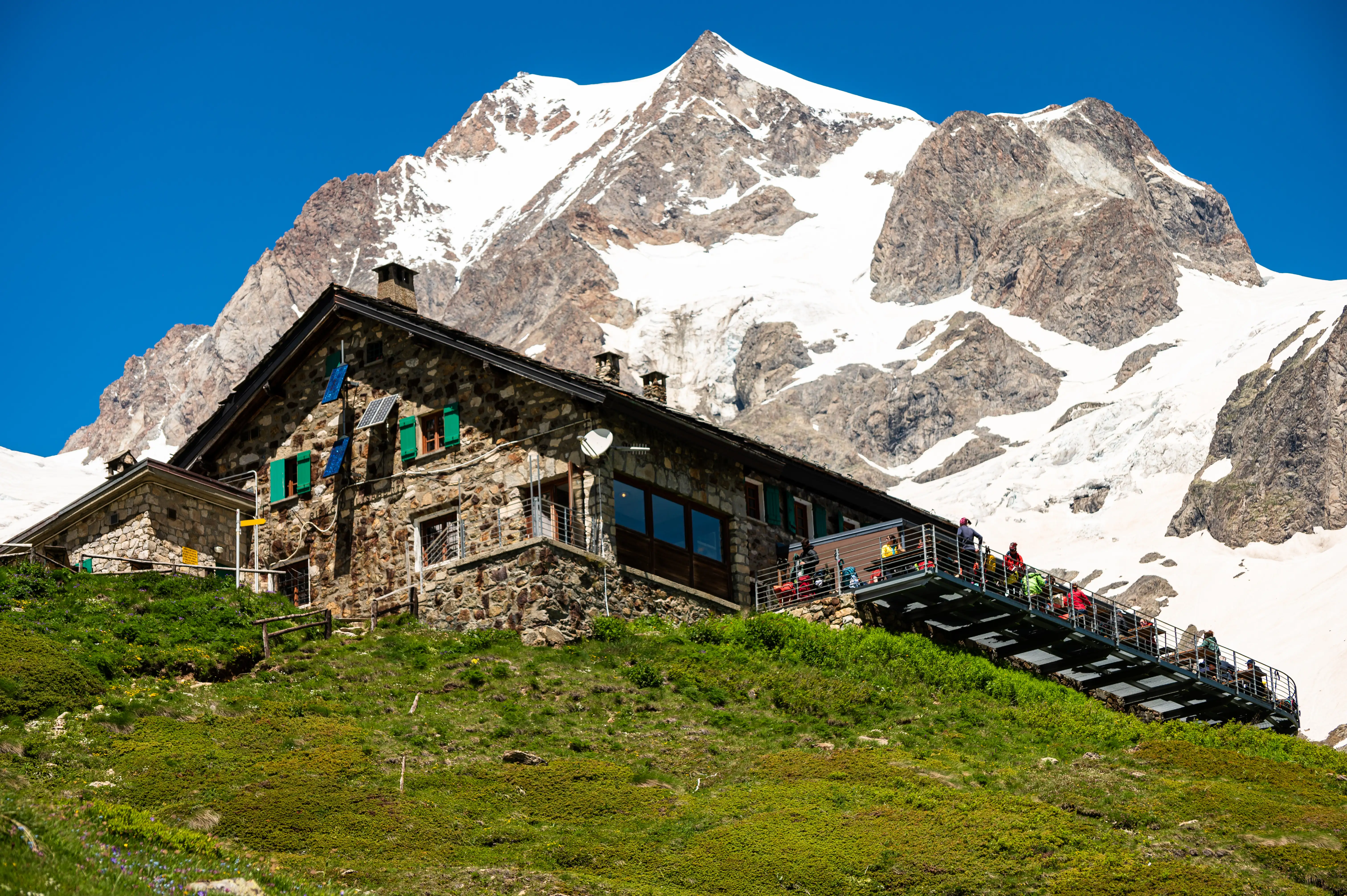 A refuge hut with an Alpine mountain backdrop