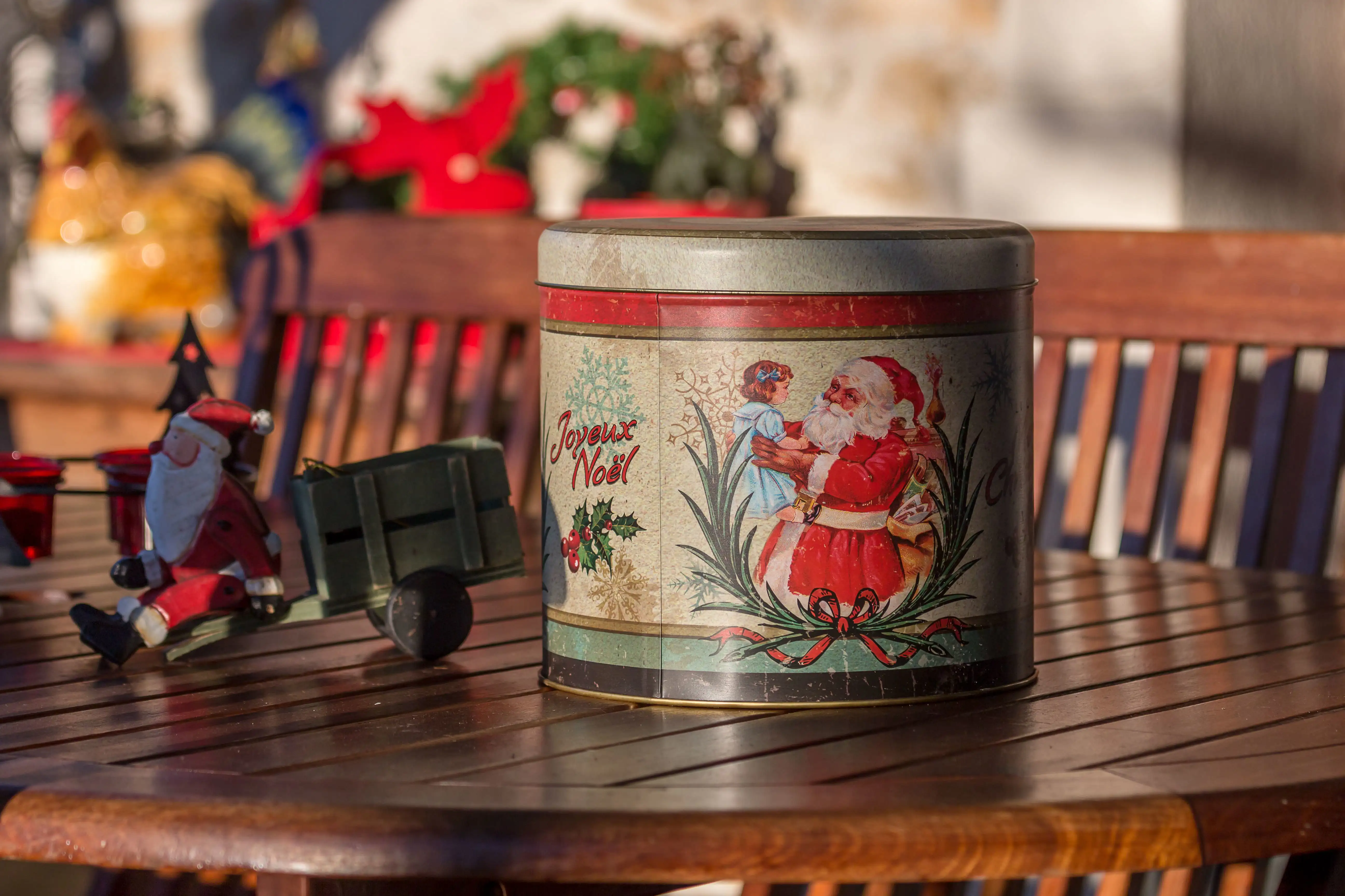 A vintage biscuit tin with a Christmas scene on a table