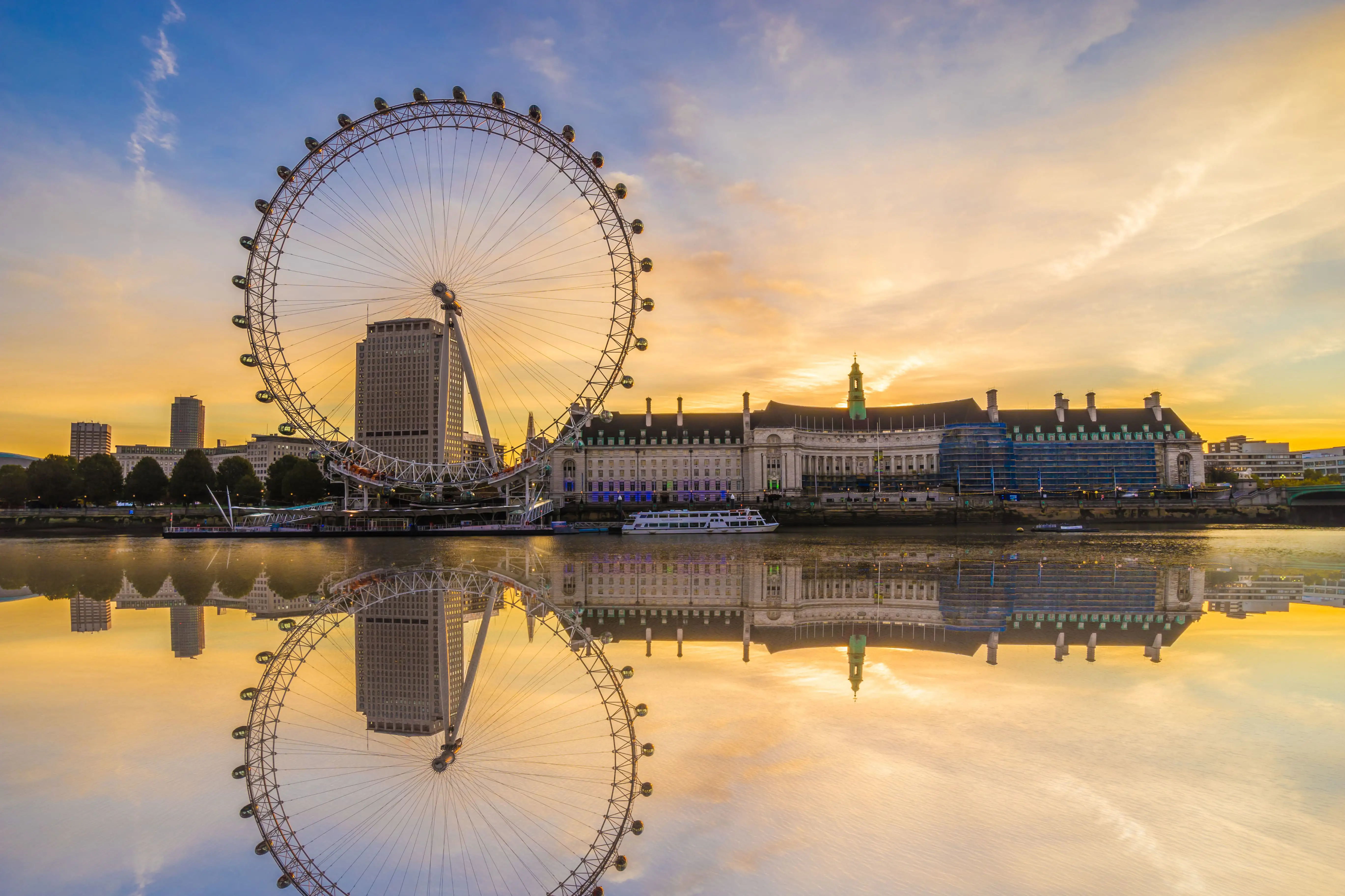 Le London Eye avec son reflet sur la Tamise au lever du soleil.