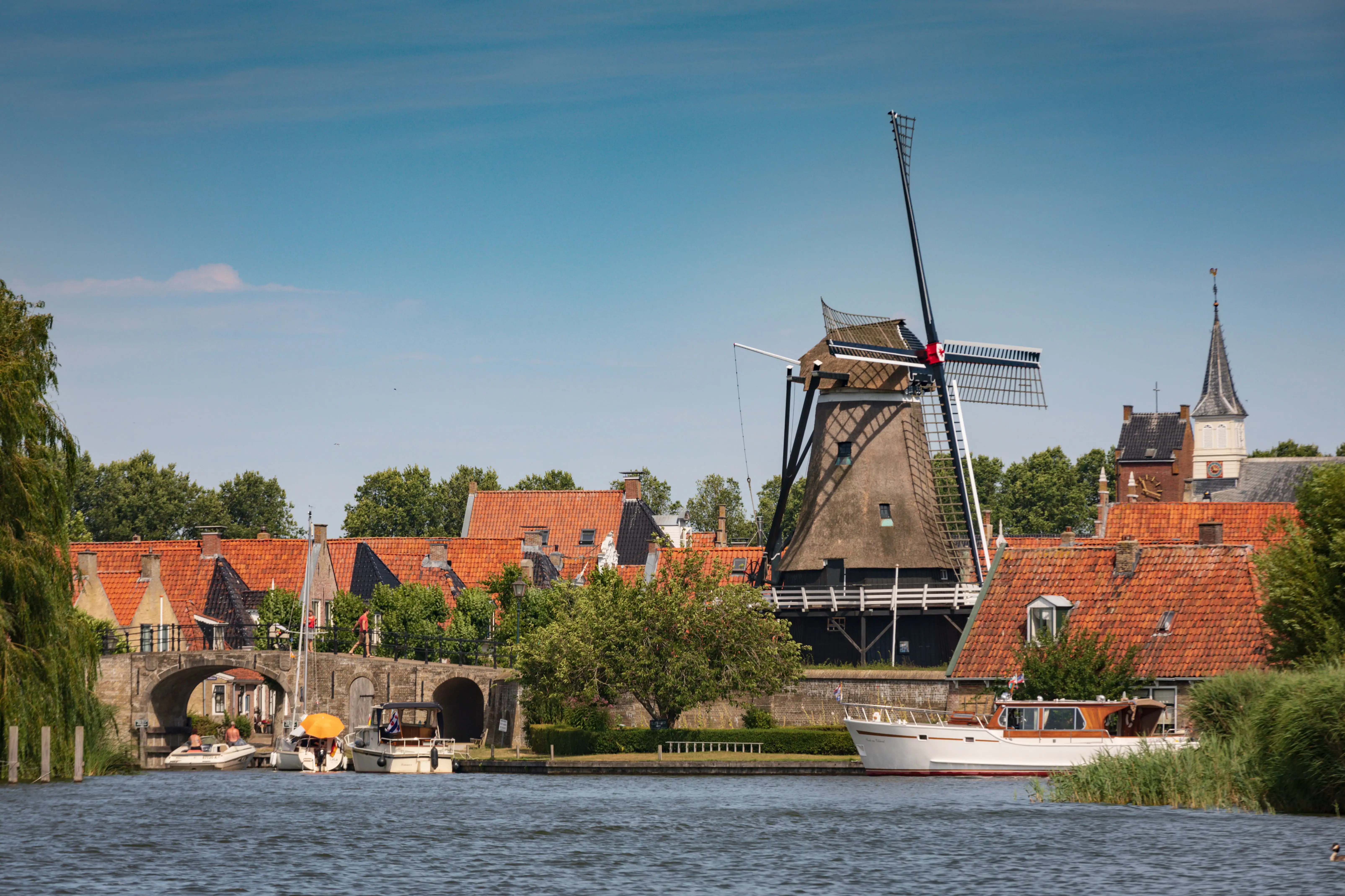 A large old windmill is the largest feature on a small town skyline on a summer’s day