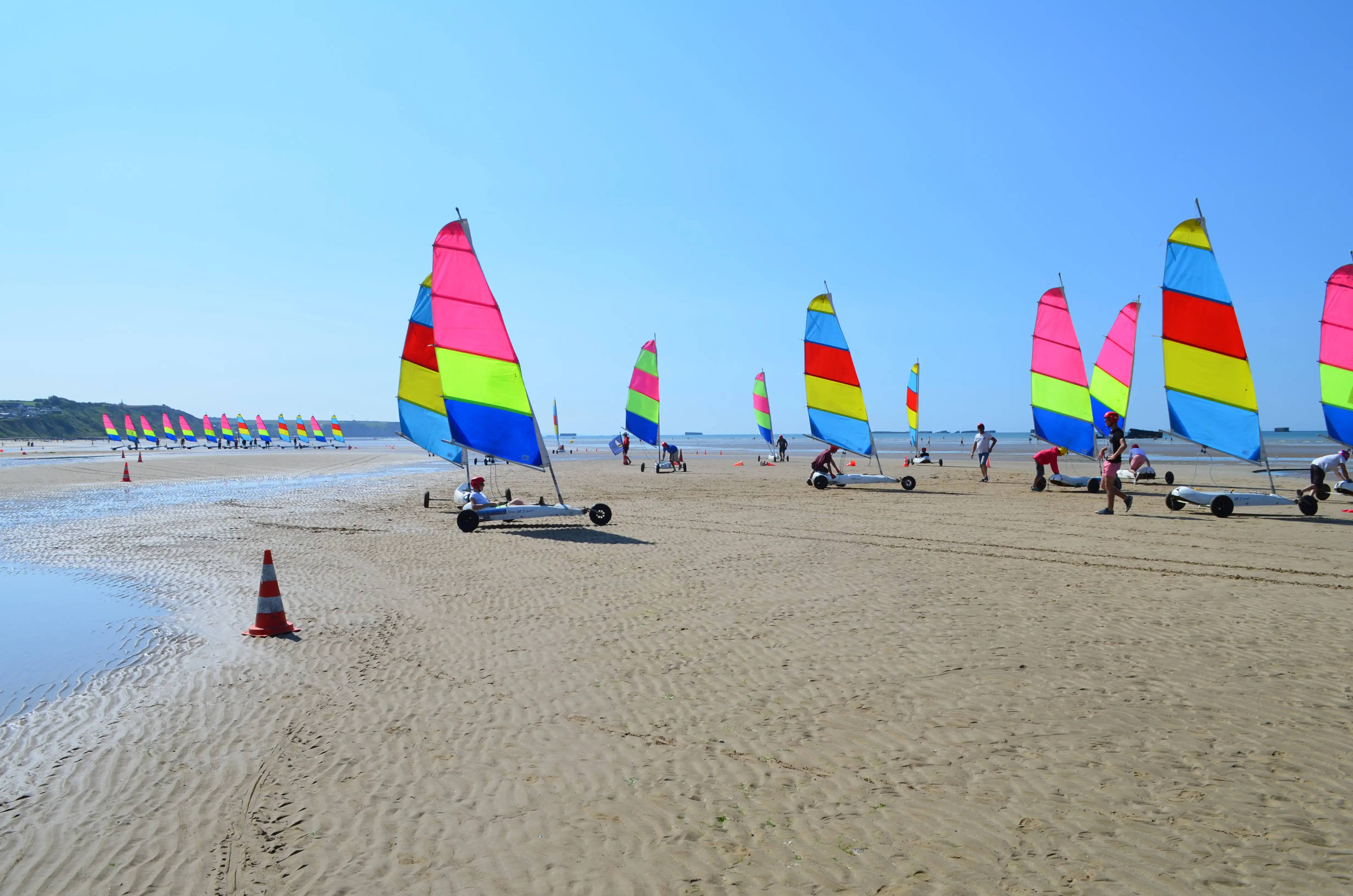 Sand yachters with colourful sails on a beach