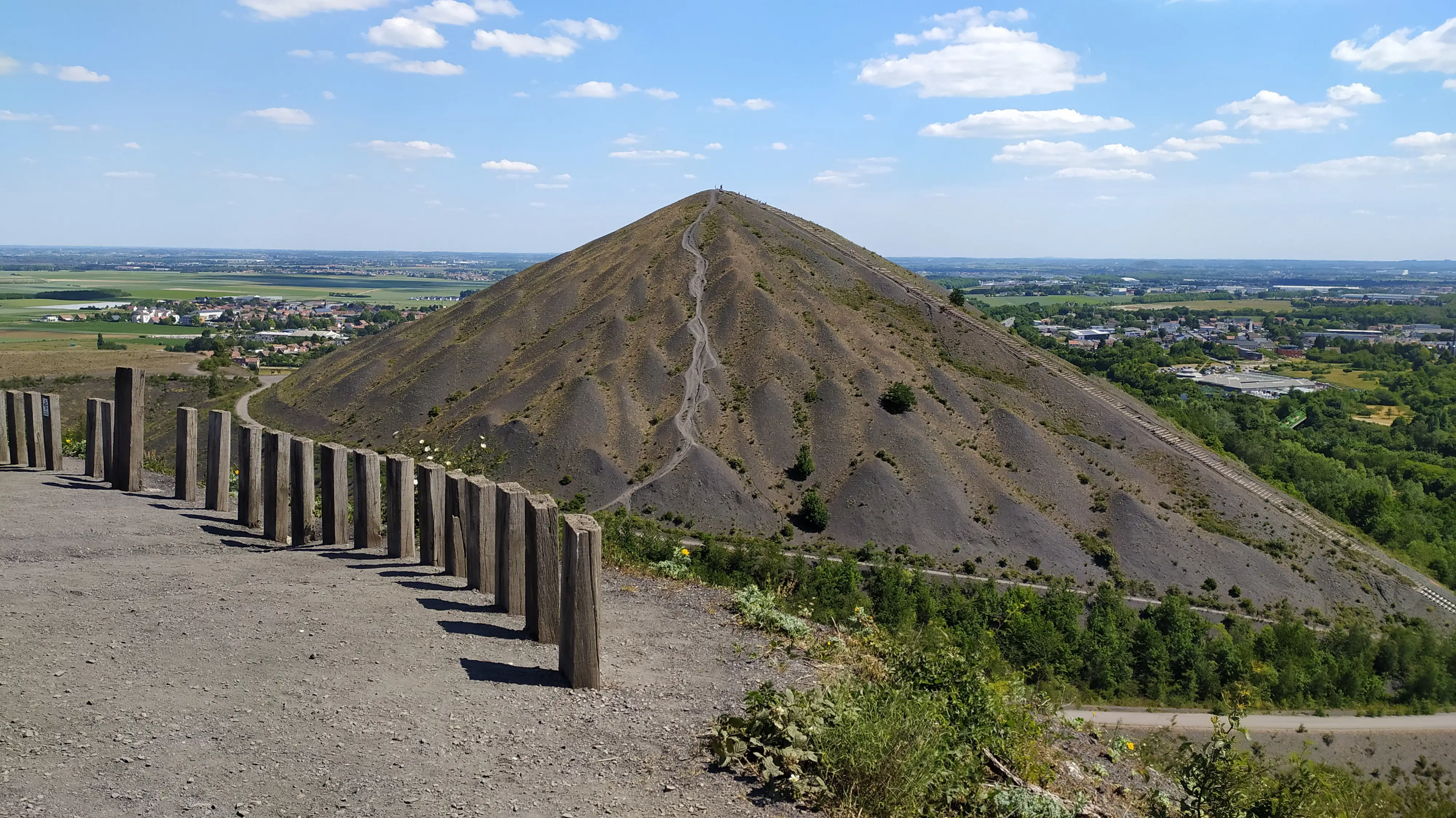 Pyramid-shaped slag heap overlooking a rural plain