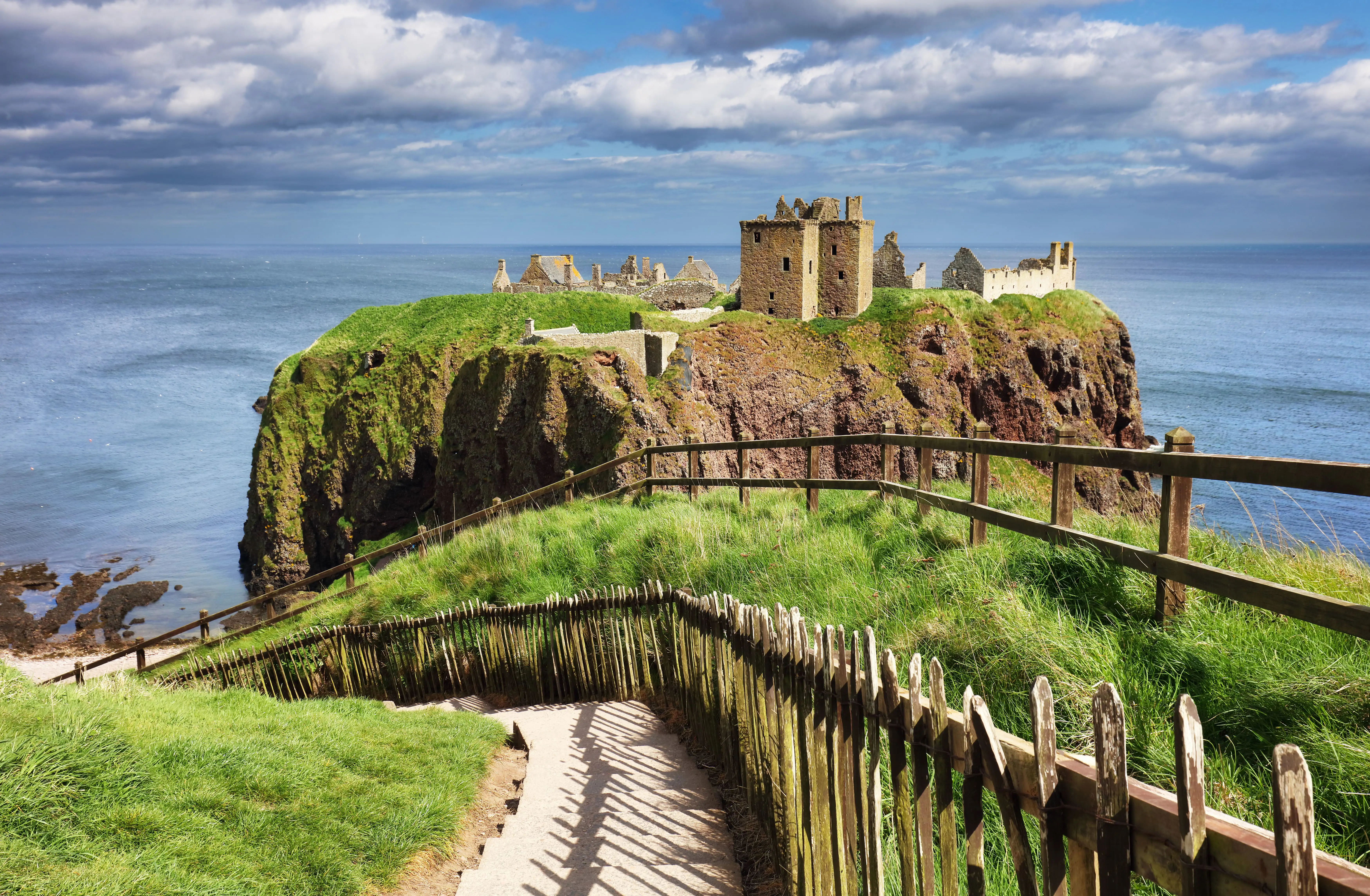 Un sentier bordé d’une barrière menant à une forteresse médiévale, le château de Dunnottar