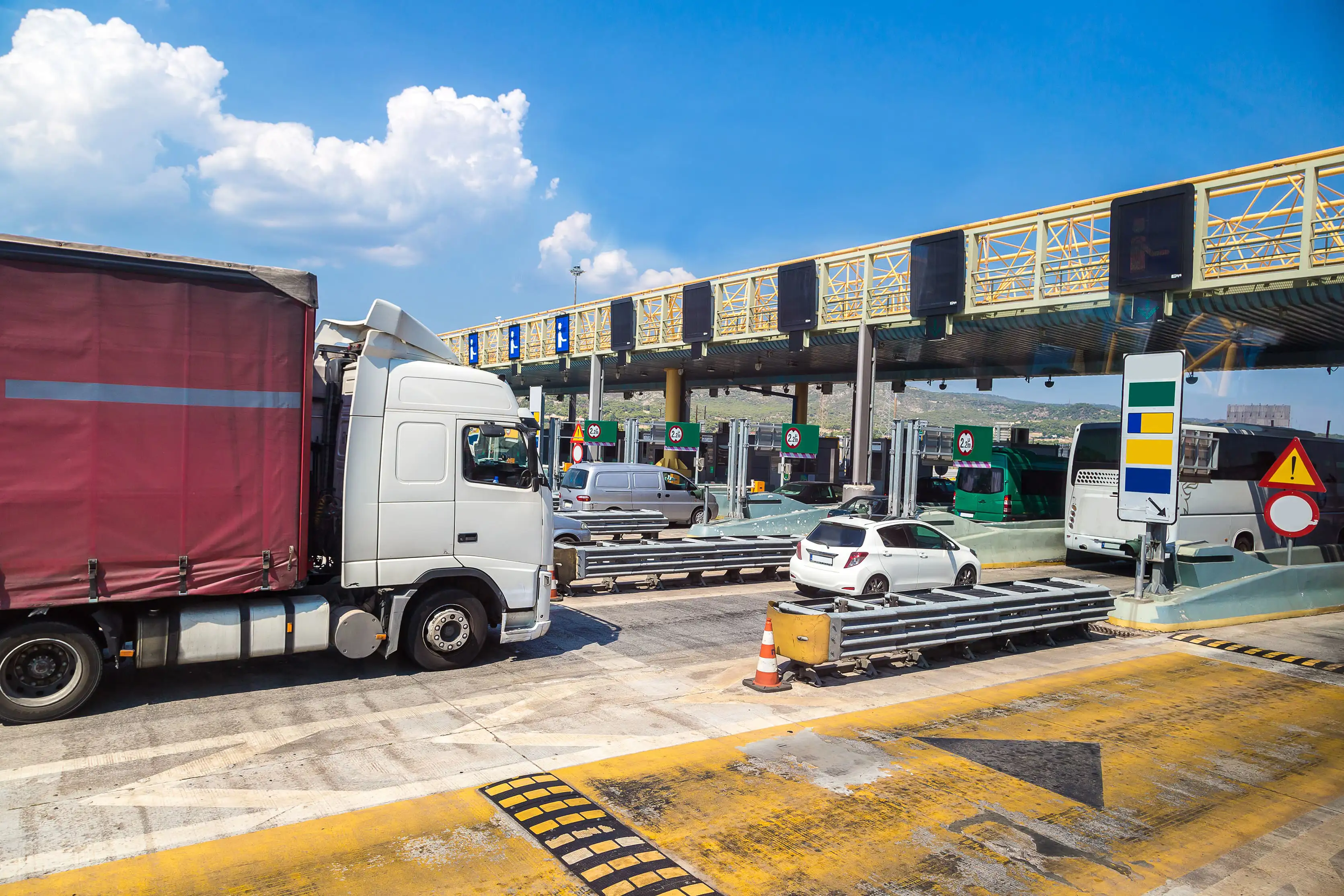 Cars and a truck at a toll station on a European road
