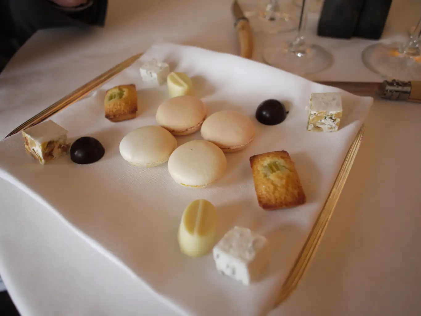 A dessert plate with various sweet treats, such as macarons and nougat