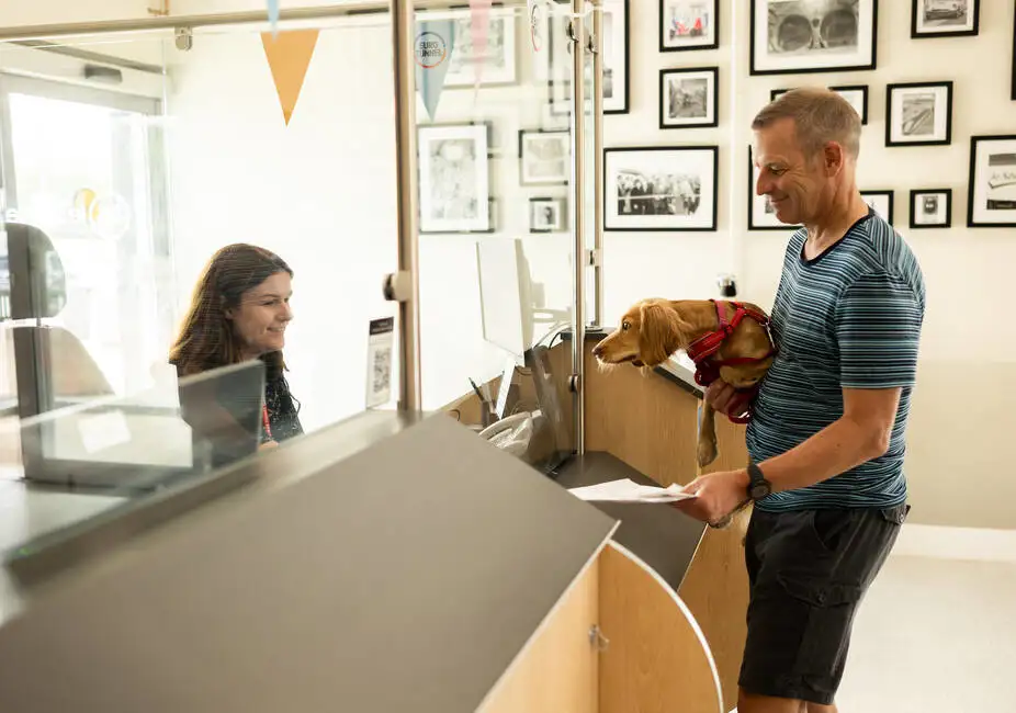 Man holding dog at Pet Reception